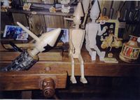 Pinocchio puppets in diverse stages of construction in a shop window in Florence.
